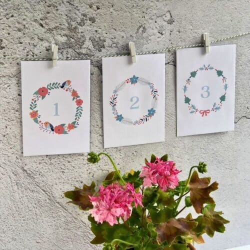geranium themed advent calendar envelopes hung up with a wreath design