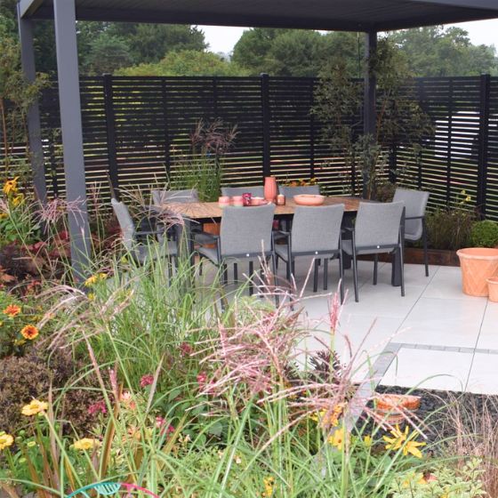 outside eating area under a gazebo surrounded by flowers